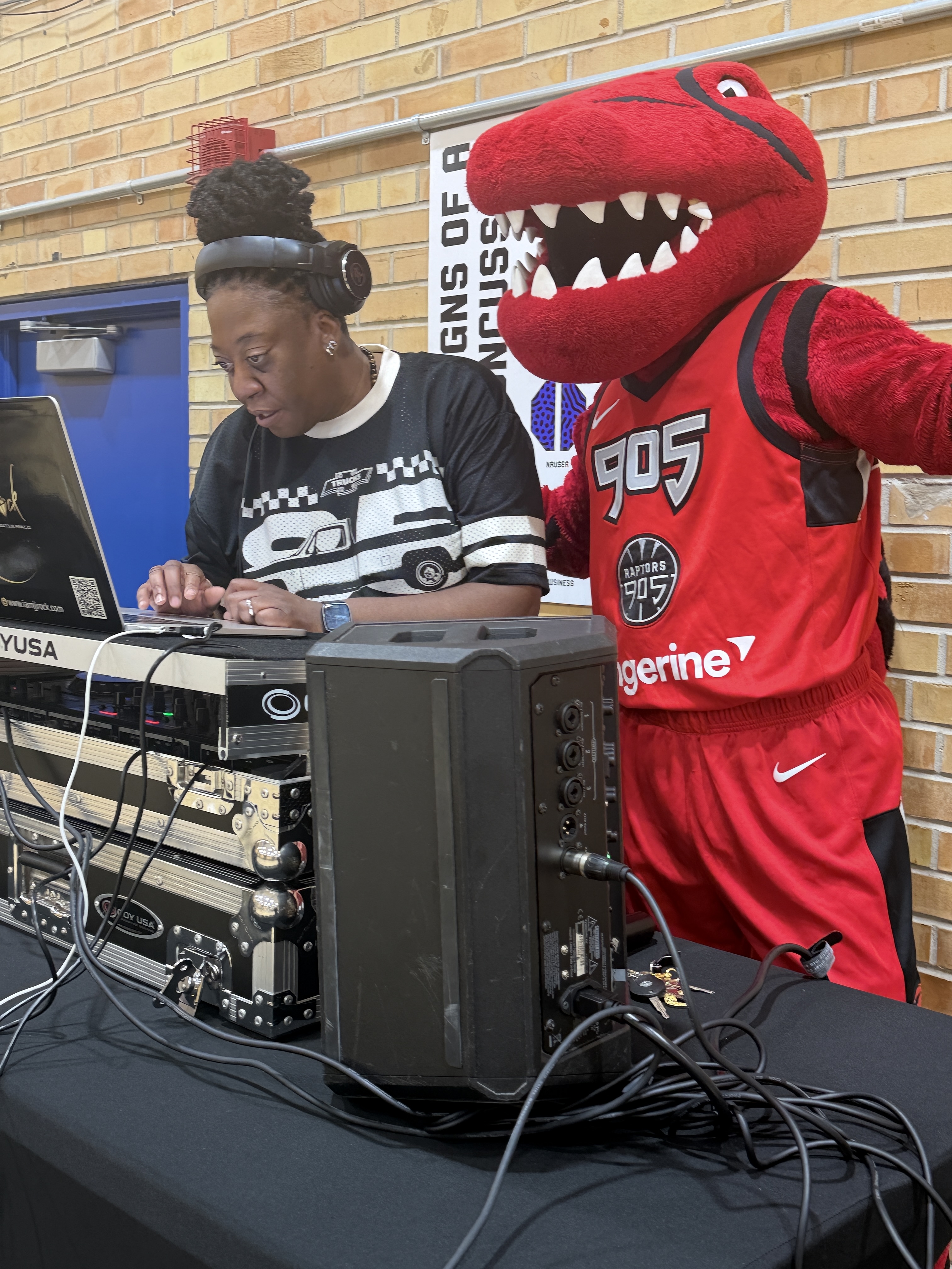 DJ JJ Rock at her laptop alongside the Raptors 905 mascot