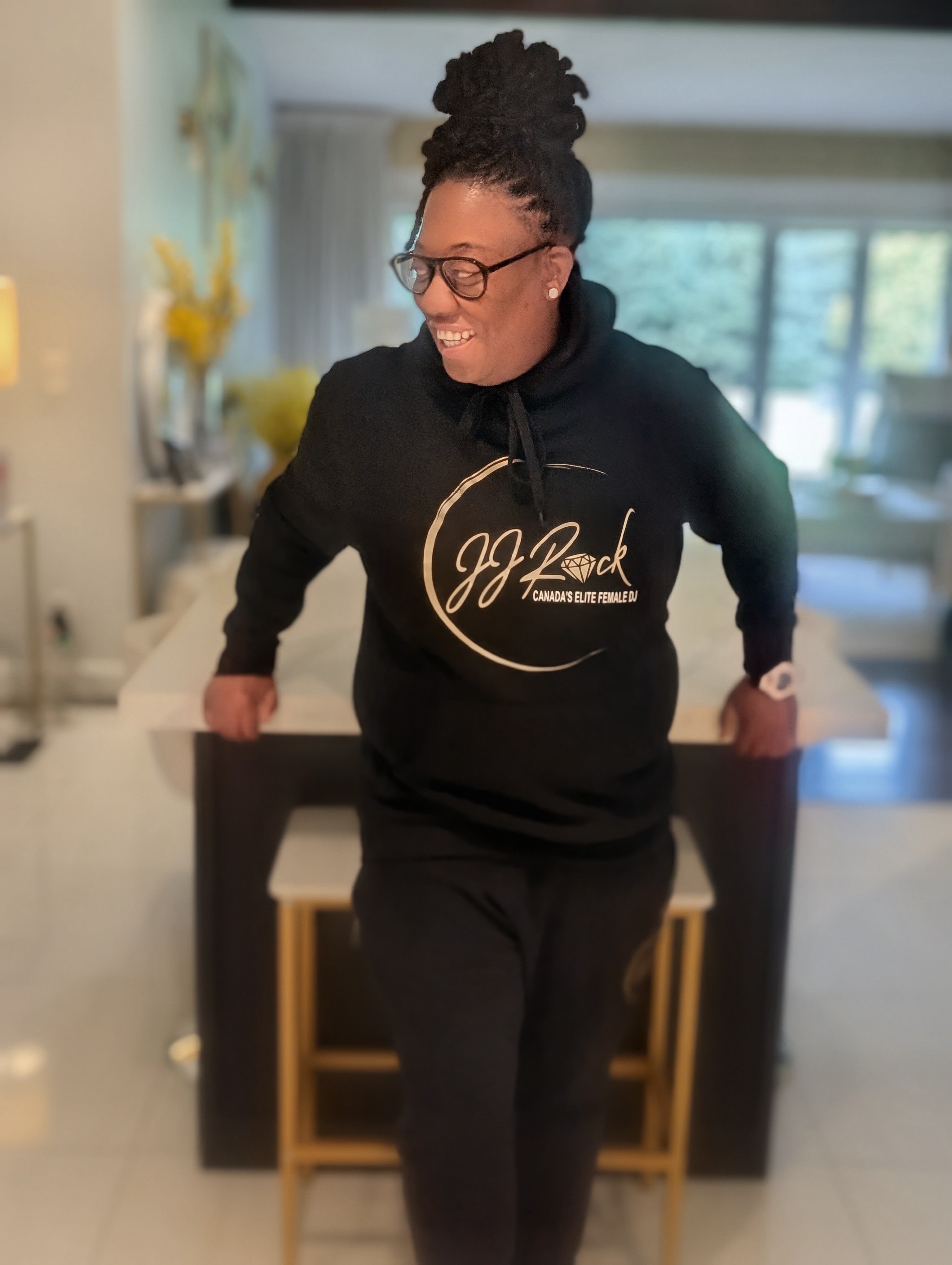 DJ JJ Rock smiling in her own branded hoodie
